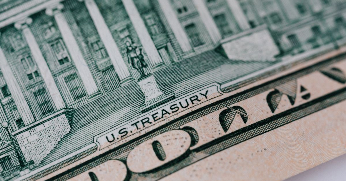 From above ten dollar banknote with inscription and United States treasury building placed on table